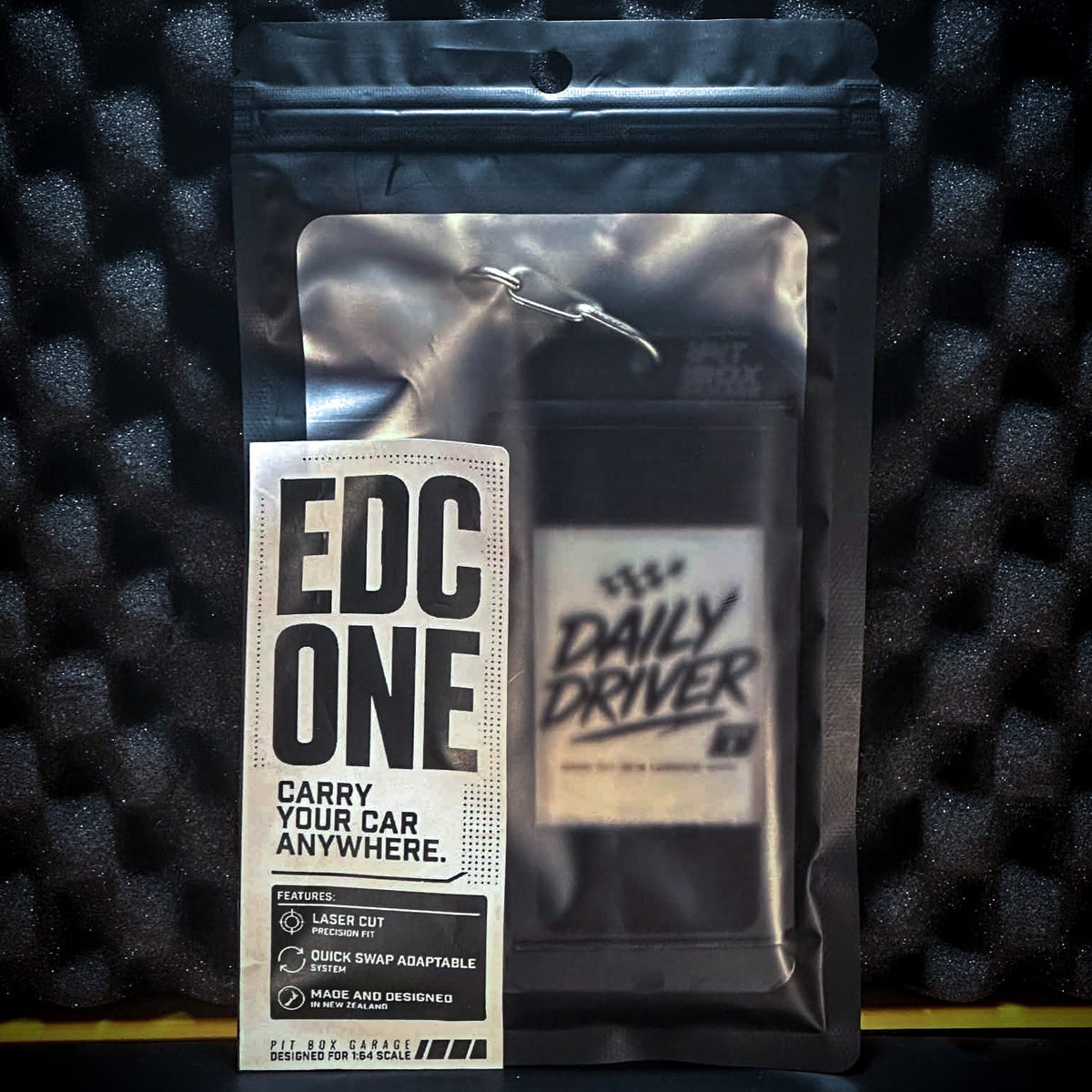 Packaged product with 'EDC One' and 'Daily Driver' branding on a textured black background