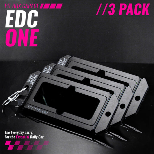 Three black PITNE EDC One slim cardholder keychains arranged in a fan-like stack on a dark background, with a silver keyring attached to the front. The image features promotional text overlays reading 'EDC ONE', 'PIT BOX GARAGE', and '//3 PACK'.